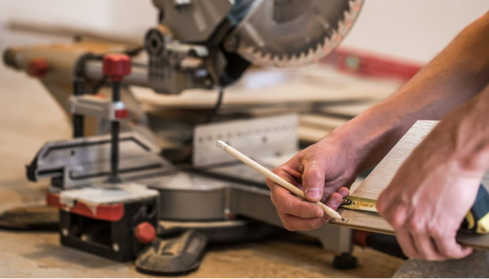How does a miter saw work to make straight cuts